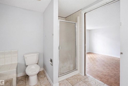 Bathroom featuring a glass-enclosed shower, tiled flooring, and a white toilet - 3220 42A Avenue, Edmonton, AB 