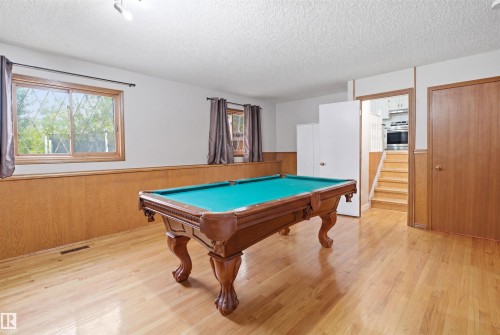 Recreation room featuring wood-finish flooring and wainscoting - 3220 42A Avenue, Edmonton, AB 
