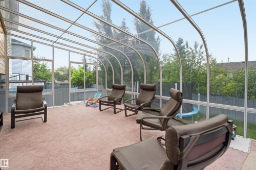 Curved glass sunroom with aluminum framing, full height windows, and light beige carpeting - 3220 42A Avenue, Edmonton, AB 