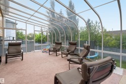 Curved glass sunroom with aluminum framing, full height windows, and light beige carpeting - 