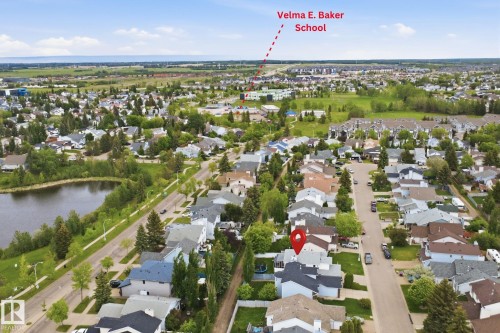 Aerial perspective showcasing a residential neighborhood with a large pond and green spaces - 3220 42A Avenue, Edmonton, AB 