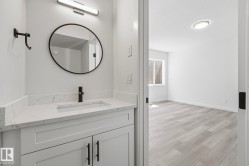 Bathroom vanity featuring a quartz countertop with an integrated sink and matte black faucet - 