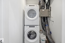 Dedicated laundry area featuring a stacked washer and dryer - 