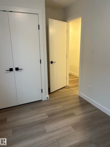 Contemporary wood-finish flooring complements crisp white walls - 11012 132 Street, Edmonton, AB 