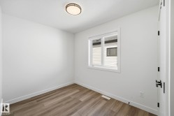 Room featuring wood-finish flooring, white baseboards, and a neutral wall palette - 