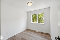 Interior room featuring wood-finish flooring and a contemporary flush-mount ceiling light - 