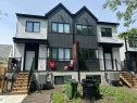Modern duplex featuring a dual-tone facade with dark vertical siding and light horizontal siding - 11012 132 Street, Edmonton, AB 