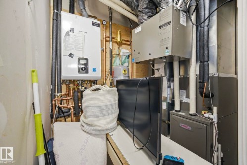 Stackable washer and dryer unit in a hallway laundry closet - 11012 132 Street, Edmonton, AB 