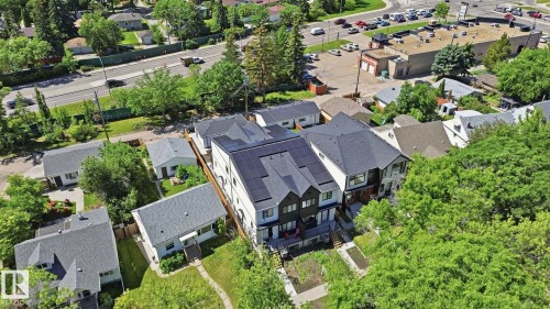 Modern multi-level residence featuring a dark gray roof, solar panel installation, and light gray exterior siding - 11012 132 Street, Edmonton, AB 