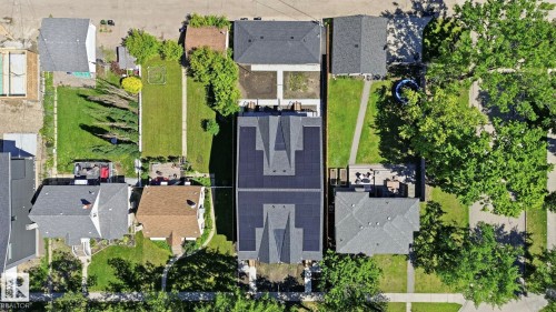 Aerial perspective showcasing a property with a dark-shingled roof and integrated solar panels - 11012 132 Street, Edmonton, AB 