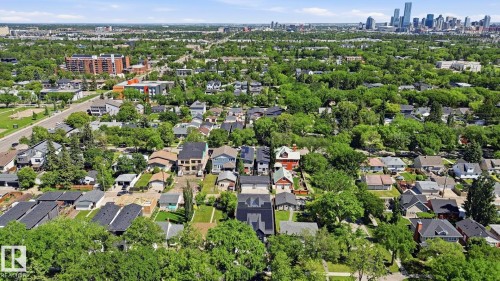 Aerial perspective showcasing a verdant residential area with a prominent city skyline in the distance - 11012 132 Street, Edmonton, AB 