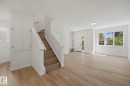 Open-concept living area with wood-finish flooring, white walls, and recessed lighting - 11012 132 Street, Edmonton, AB 