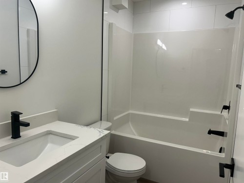 Bathroom featuring a white vanity with an integrated sink and light-toned countertop - 11007 132 Street, Edmonton, AB 