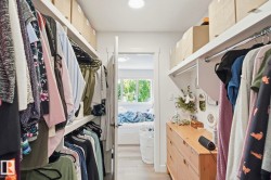 Custom closet organization system featuring multiple hanging rods and integrated shelving - 
