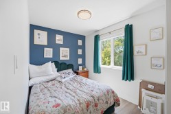 Bedroom featuring an accent wall, a large window, recessed lighting, and wood-finish flooring - 