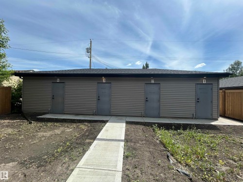Four individual units with horizontal siding, a dark shingle roof, and a concrete pathway - 11007 132 Street, Edmonton, AB 