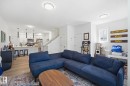 Bright living area featuring wood-finish flooring, white walls, and contemporary ceiling light fixtures - 11007 132 Street, Edmonton, AB 