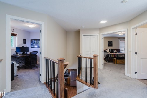 Upper level landing featuring wood and metal stair railing, light-colored carpeting, recessed lighting, and access to additional rooms - 5206 Cercle Ciel Crescent, Beaumont, AB 