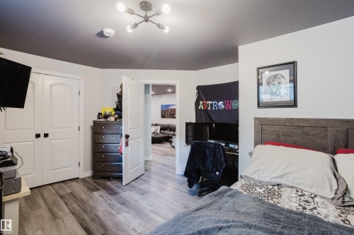 Wood-finish flooring throughout, complemented by white walls and a dark accent ceiling - 5206 Cercle Ciel Crescent, Beaumont, AB 