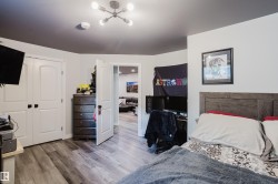 Wood-finish flooring throughout, complemented by white walls and a dark accent ceiling - 