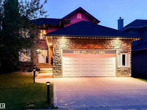 Two-story residence featuring a stone-clad garage with an automatic door and integrated windows - 5206 Cercle Ciel Crescent, Beaumont, AB 
