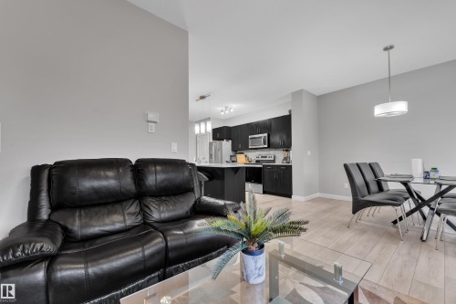Open-concept living area featuring light wood-finish flooring, neutral wall tones, and recessed lighting - 9328 Pear Link Link, Edmonton, AB 