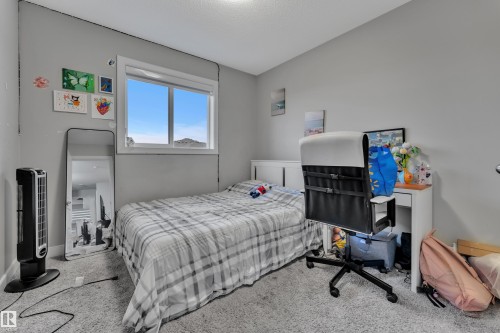 Well-lit room featuring a white-framed window, light gray walls, and textured carpeting - 9328 Pear Link Link, Edmonton, AB 