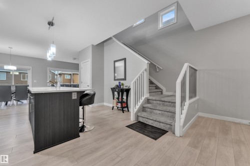 Open-concept living space with light wood-finish flooring - 9328 Pear Link Link, Edmonton, AB 