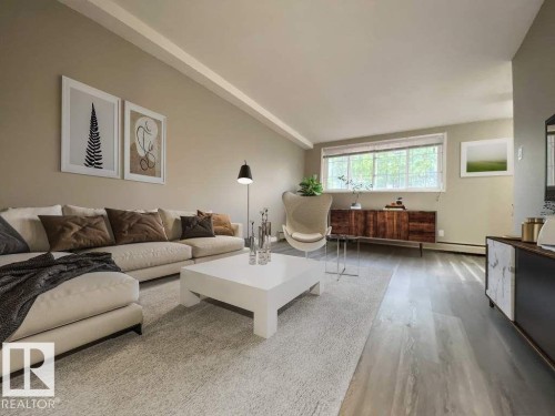 Spacious living area featuring light-toned walls, wood-finish flooring, and a large window with blinds - 107 Village Acres Northwest, Edmonton, AB - Indoor Photo Showing Living Room