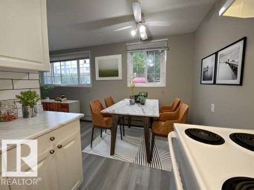 Dining area featuring a ceiling fan, two windows, and wood-finish flooring - 107 Village Acres Northwest, Edmonton, AB - Indoor Photo Showing Dining Room