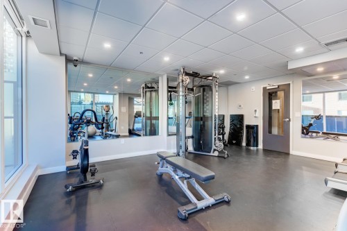 Fitness facility featuring resilient flooring, full-height mirrored walls, recessed lighting, and expansive windows - 2902 10180 103 Street, Edmonton, AB 