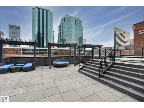 Rooftop terrace with paver flooring, multiple pergolas, and a tiered staircase featuring integrated lighting and metal railings - 2902 10180 103 Street, Edmonton, AB 