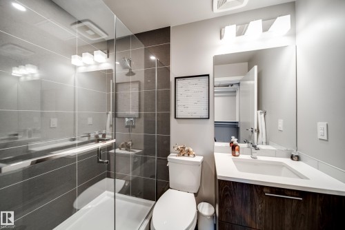 Modern bathroom featuring a glass-enclosed shower with gray tiled walls and a white shower pan - 2902 10180 103 Street, Edmonton, AB 