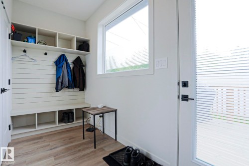 Built-in mudroom storage featuring a bench, cubbies, and overhead shelving - 12842 121 Street, Edmonton, AB 