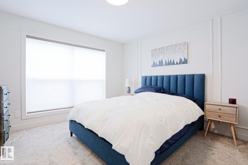 Recessed lighting illuminates a spacious room featuring wall paneling and neutral carpet - 12842 121 Street, Edmonton, AB 