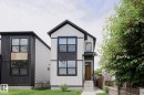 Modern two-story residence featuring a white vertical siding facade with black accents and a dark-pitched roof - 12842 121 Street, Edmonton, AB 
