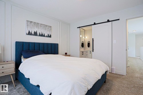 White paneled accent wall with integrated barn door entry - 12842 121 Street, Edmonton, AB 