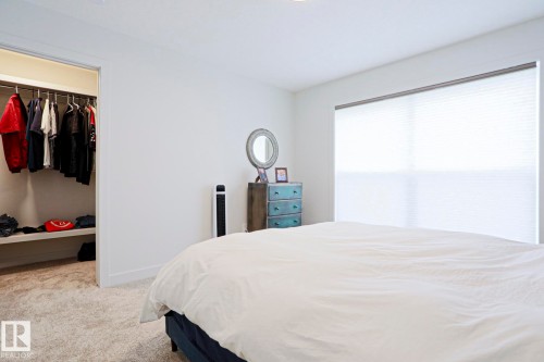 Plush carpeted flooring and a spacious walk-in closet featuring hanging rods and shelving - 12842 121 Street, Edmonton, AB 