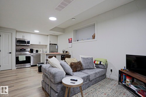 Open-concept living area featuring wood-finish flooring and recessed lighting - 12842 121 Street, Edmonton, AB 