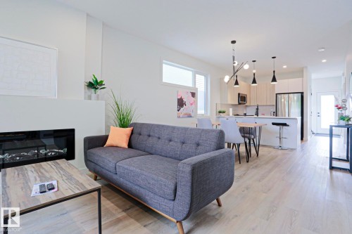 Open-concept living area with light wood-finish flooring - 12842 121 Street, Edmonton, AB 