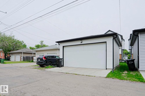 Detached garage with white horizontal siding and a black trim roofline - 12842 121 Street, Edmonton, AB 
