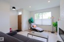 Bright living area featuring wood-finish flooring, recessed lighting, and a large window with privacy blinds - 12842 121 Street, Edmonton, AB 