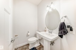 White pedestal sink with chrome fixtures and an oval mirror - 