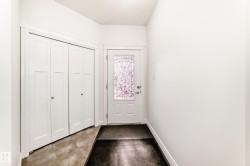 Entryway featuring a white door with decorative glass, bi-fold closet doors, and tile flooring - 