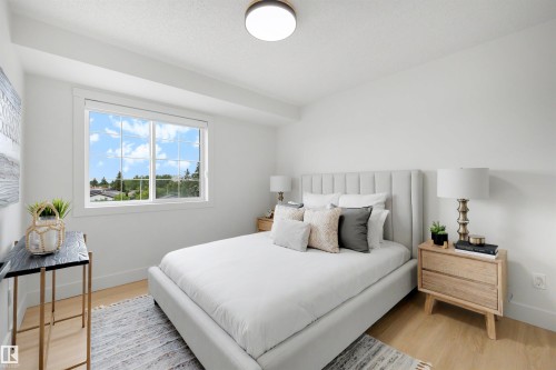 Bright bedroom with light wood-finish flooring and a large window - 12611 47 Street, Edmonton, AB 