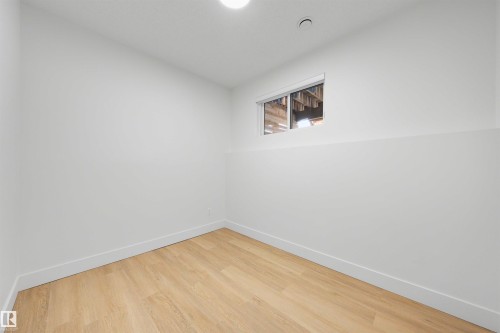 White painted walls with a small window, light wood-finish flooring, and recessed ceiling lighting - 12611 47 Street, Edmonton, AB 
