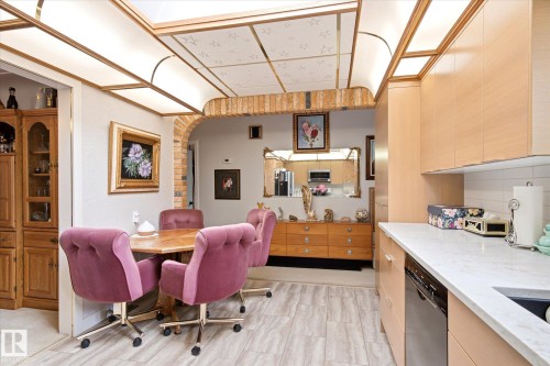 Kitchen and dining area featuring light wood-finish cabinetry, white countertops, and a subway tile backsplash - 9747 67 Avenue, Edmonton, AB 