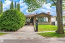 Stone facade residence featuring a prominent front window and an integrated front entry - 9747 67 Avenue, Edmonton, AB 