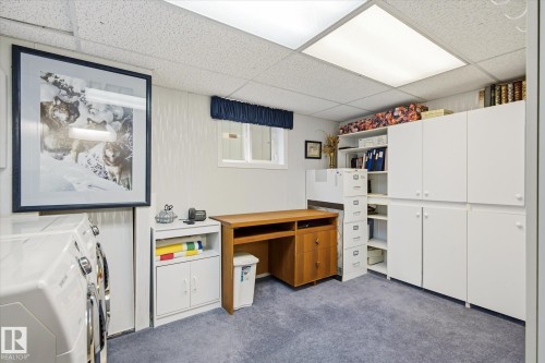 Dedicated room featuring white built-in cabinetry, recessed lighting, and blue carpeting - 9747 67 Avenue, Edmonton, AB 