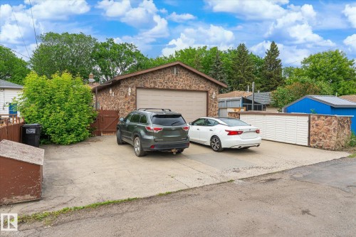 Detached garage featuring stone siding and an overhead door - 9747 67 Avenue, Edmonton, AB 
